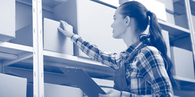 Junge Frau prüft Bestand im Lager anhand einer Liste