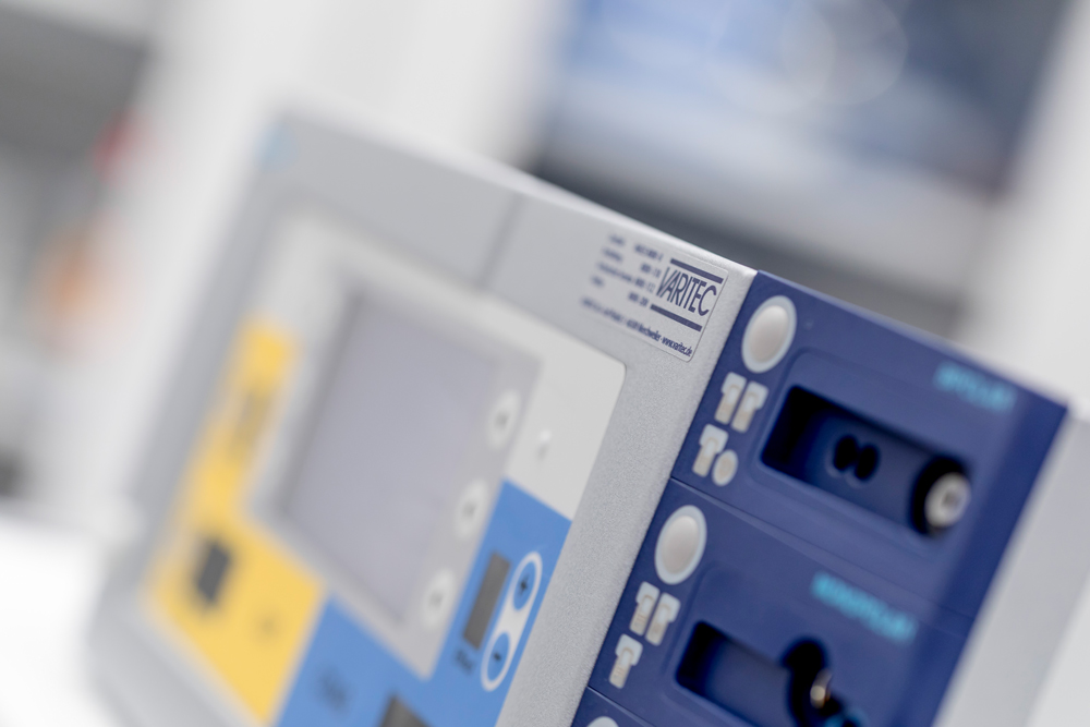 Nahaufnahme eines medizinischen Geräts mit einem Geräteaufkleber von VARITEC und mehreren Anschlüssen und Tasten
